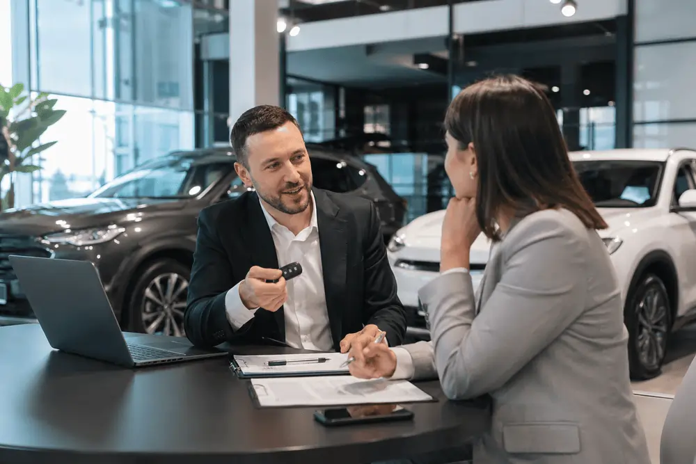 Übergabe des neuen Firmenautos Frau bekommt beim Autohändler Auto Abo als Dienstwagen