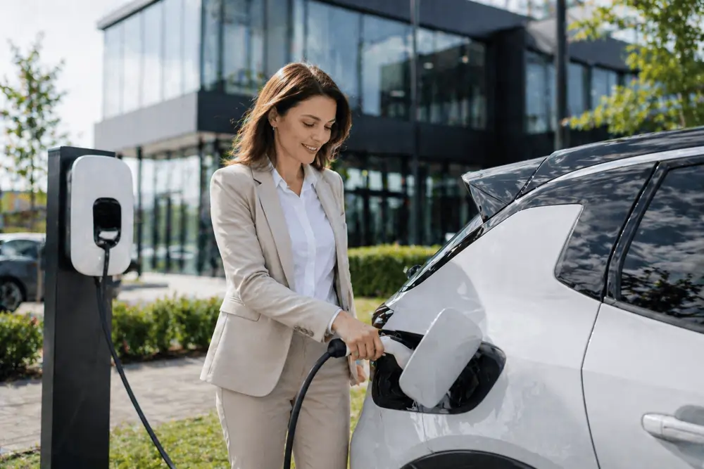 Elektroauto im Abo Frau tankt ihr Elektroauto, welches sie als Firmenwagen im Abo hat.