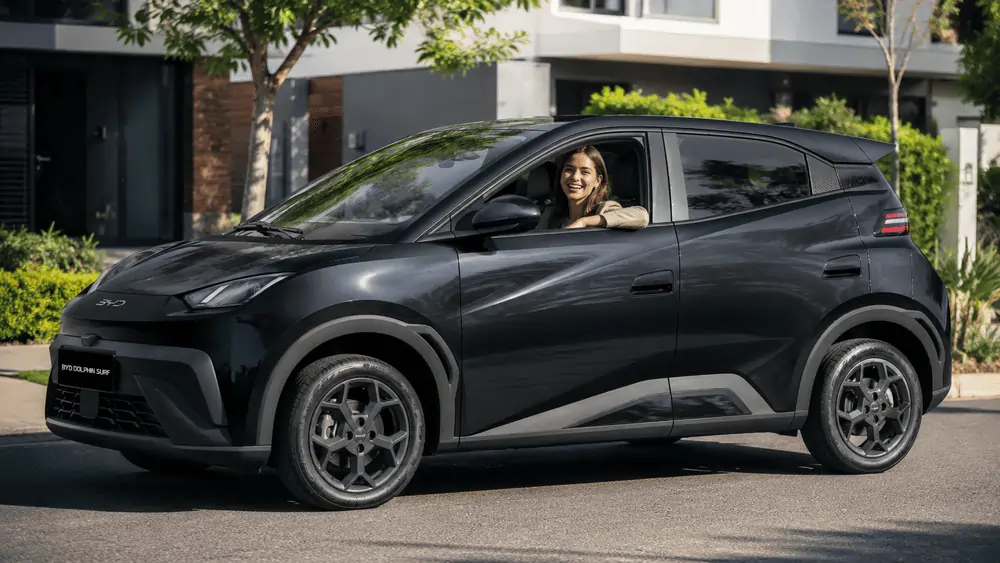 BYD Dolphin Surf im Abo – flexibel im Alltag Lächelnde Frau sitzt im schwarzen BYD Dolphin Surf, gemietet über das Auto Abo